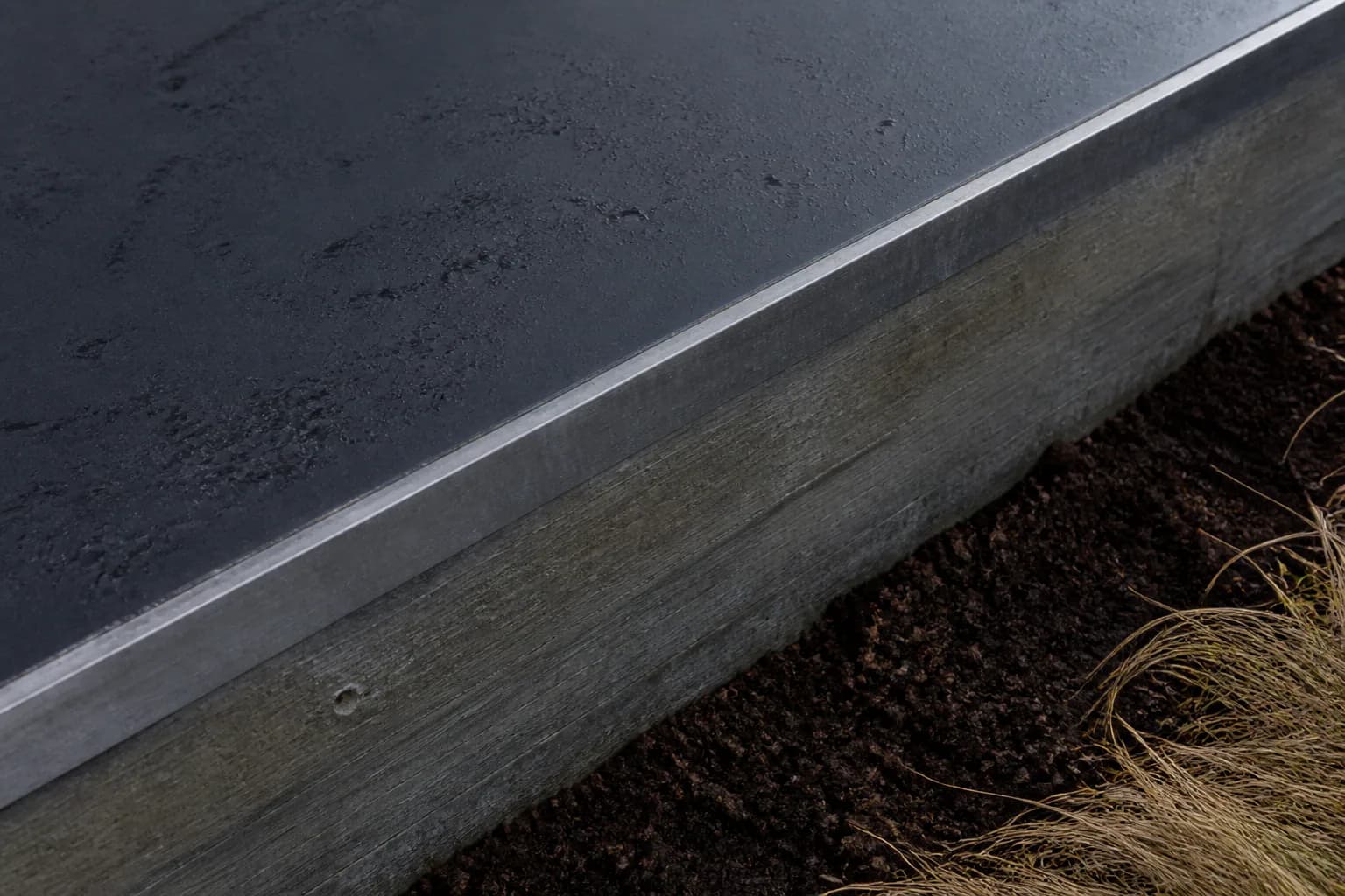 Antrasit metal, fırçalanmış çelik, beton, toprak ve kuru ot yüzeyleri